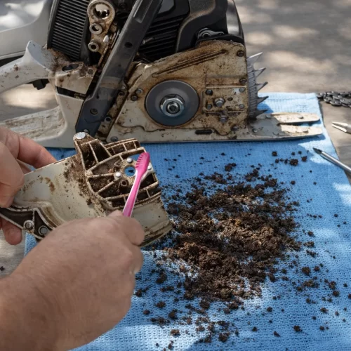 Imagen de cómo cepillar la suciedad restante de una motosierra
