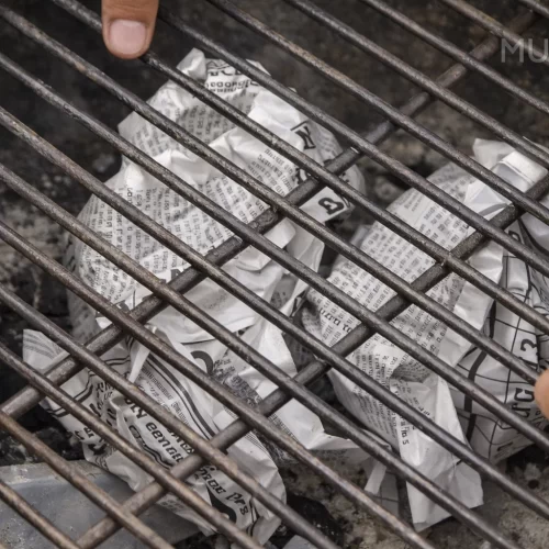 Bolas de papel de jornal por baixo da grelha do grelhador a carvão