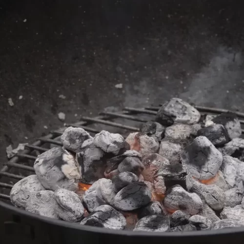 Briquetes de carvão cobertos por cinza cinzenta e prontos para cozinhar
