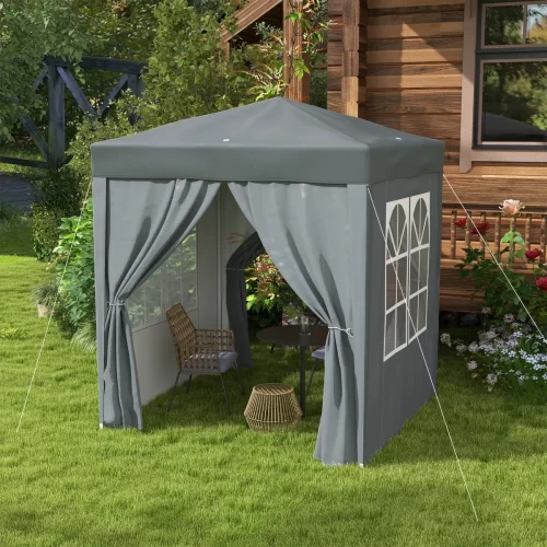 Tenda cinzenta pequena junto a uma cabana de madeira