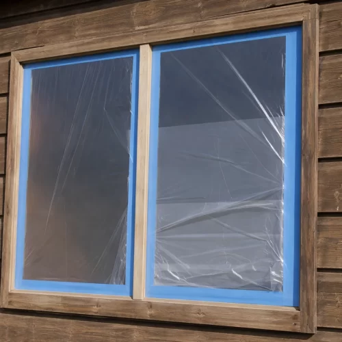 Proteger as janelas do abrigo com fita de pintor e plástico