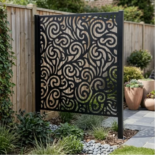 Painel decorativo de metal preto com padrão em espiral colocado diante de uma vedação de madeira