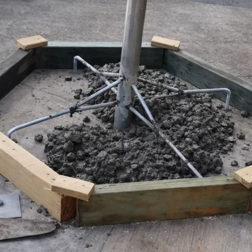 Acabamento da superfície de cimento com uma colher de pedreiro à volta do tubo central