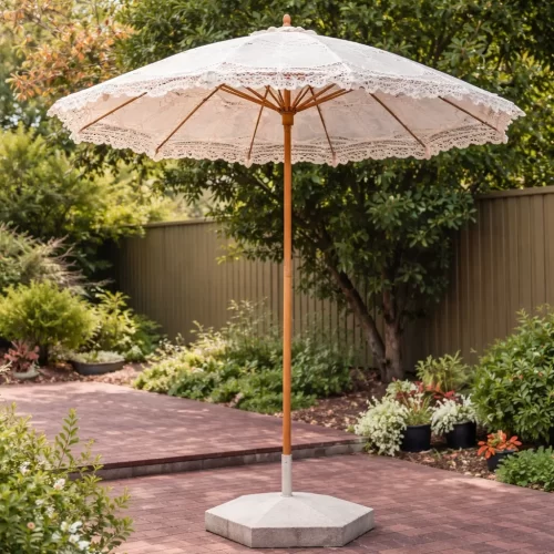 Guarda-sol decorativo branco instalado sobre uma base de cimento hexagonal terminada no jardim