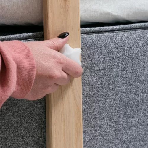 Mano sujetando la pata de madera junto a un separador