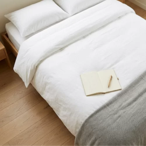 Cama feita com roupa branca e agenda de limpeza