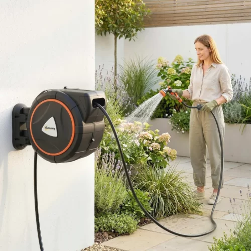 mujer-regando-jardin-enrollador-pared.webp